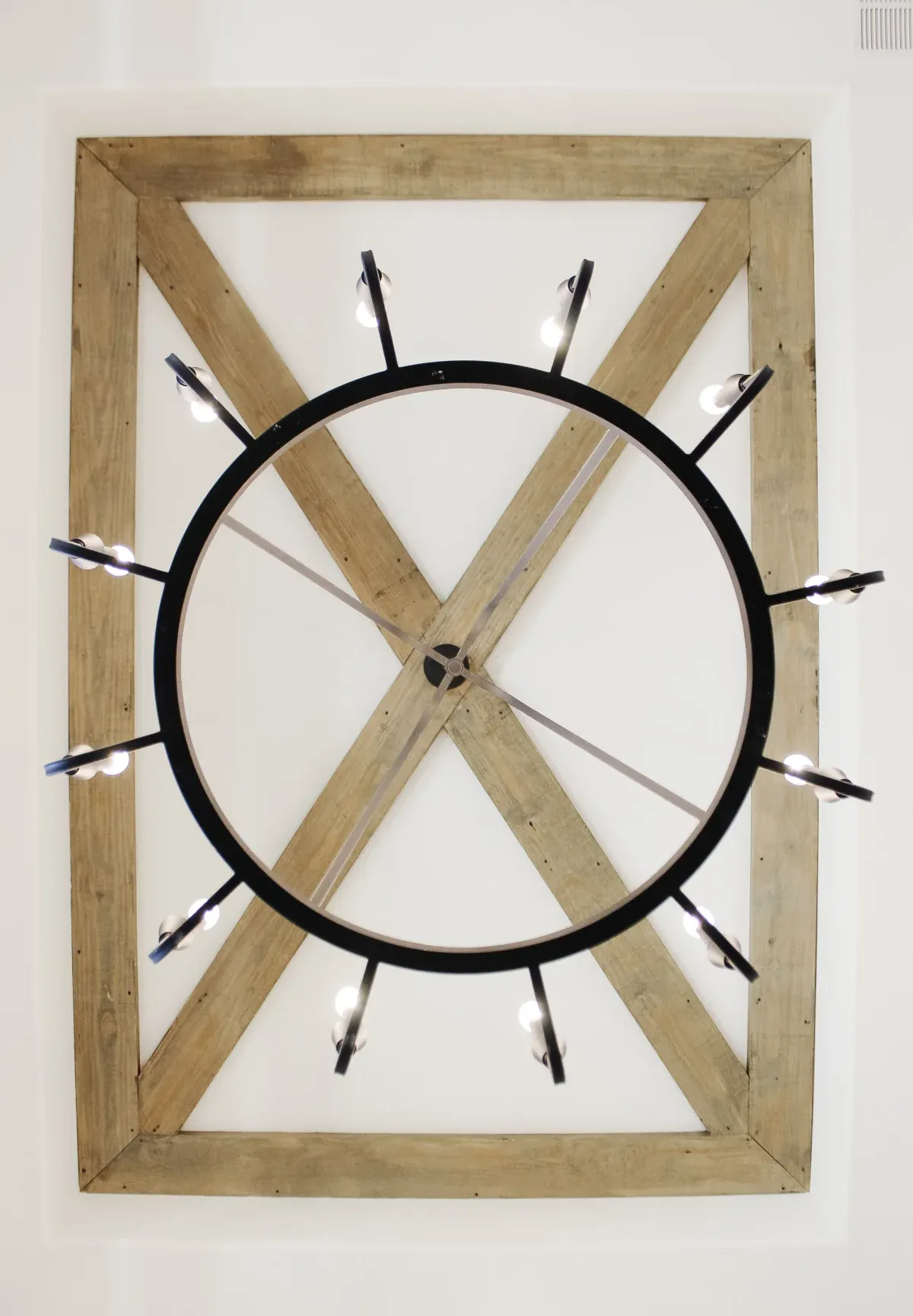 Celing light hanging from wood beams.