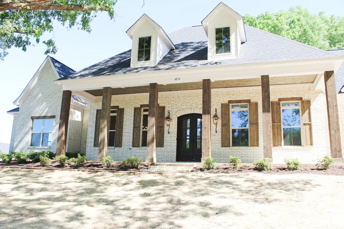 Home featuring a porch with wood support beams.